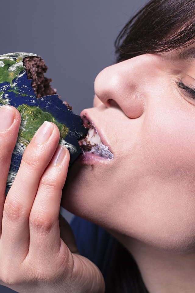 Девушка ест пирожное в виде планеты земля