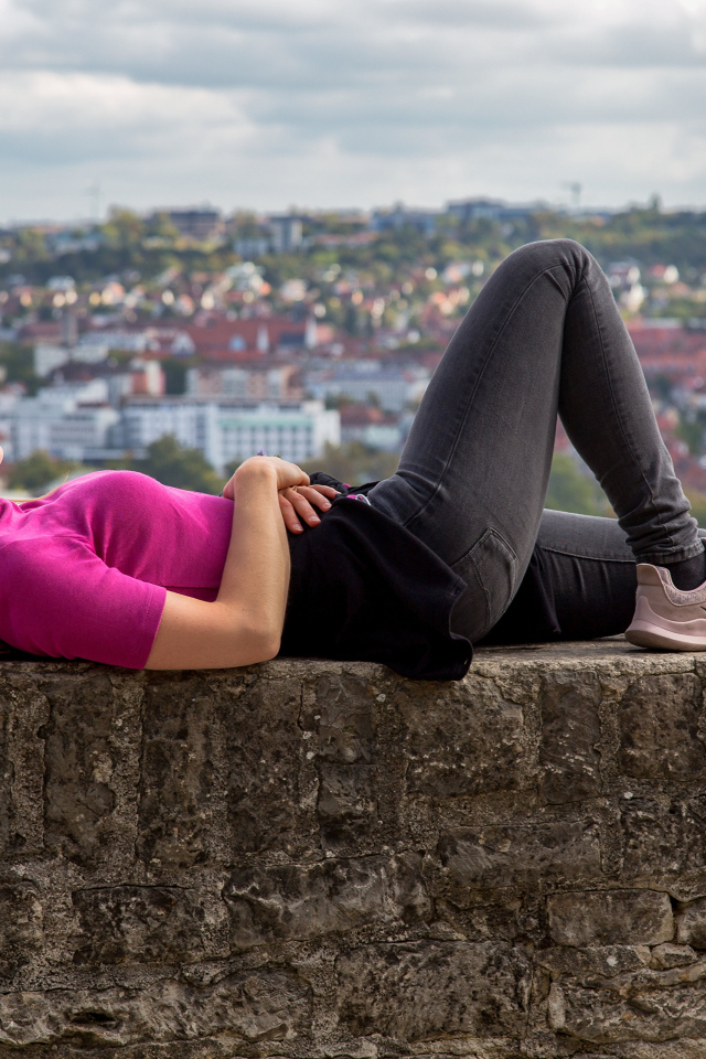 Девушка отдыхает на фоне старого города