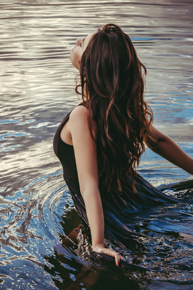 Молодая девушка купается в воде