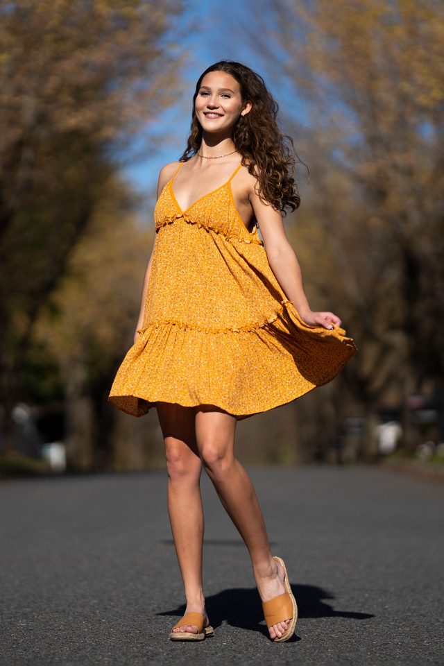 Молодая девушка в коротком платье на дороге  летом