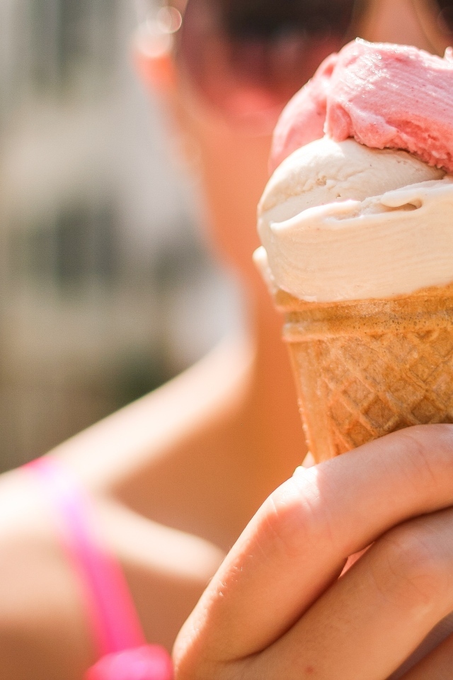 Девушка держит в руках мороженое