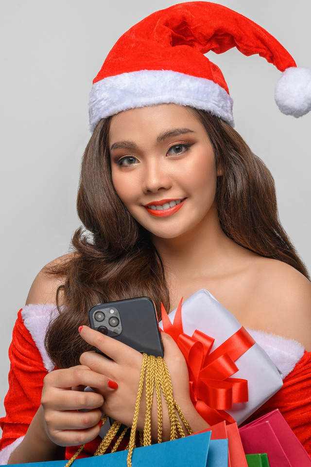 Молодая девушка азиатка с подарками на новый год