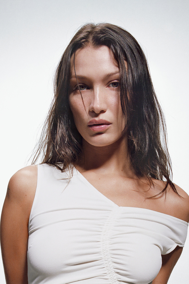 Модель Белла Хадид в белом платье на сером фоне