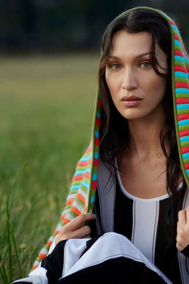 Модель Белла Хадид сидит на траве под пледом