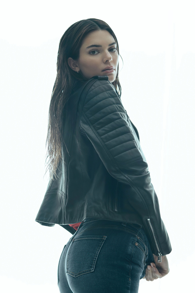 Модель Кендалл Дженнер в черной куртке на белом фоне