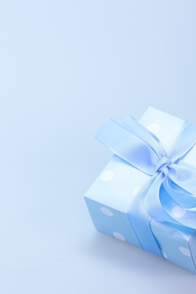Коробка для подарка с голубой лентой на сером фоне