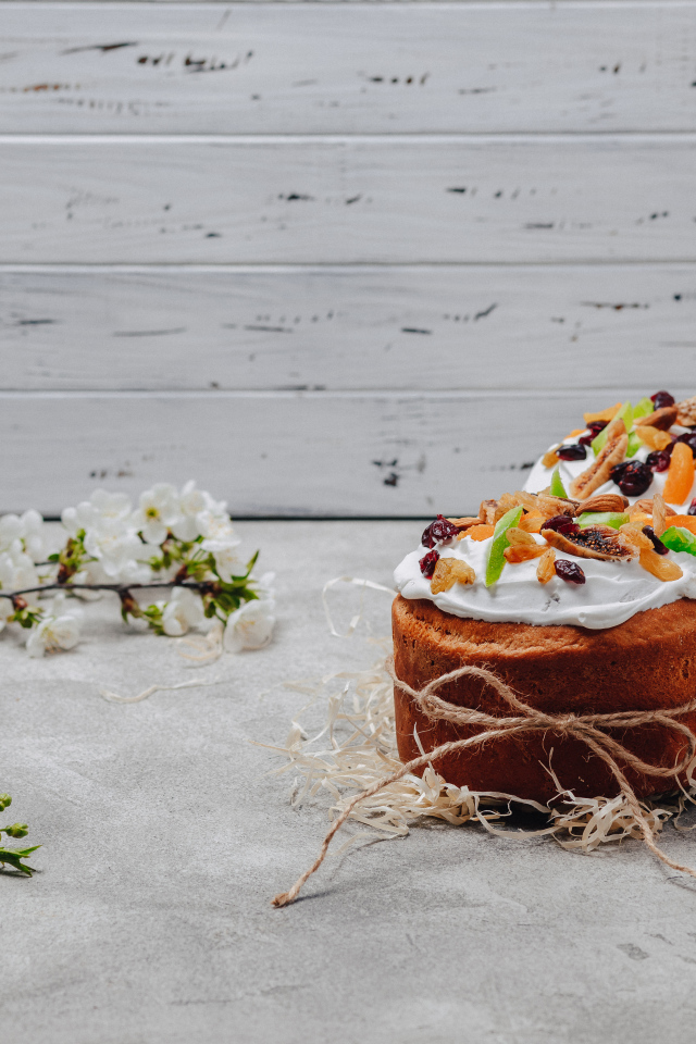 Красивые пасхальные куличи с веткой вишни на сером столе на Пасху