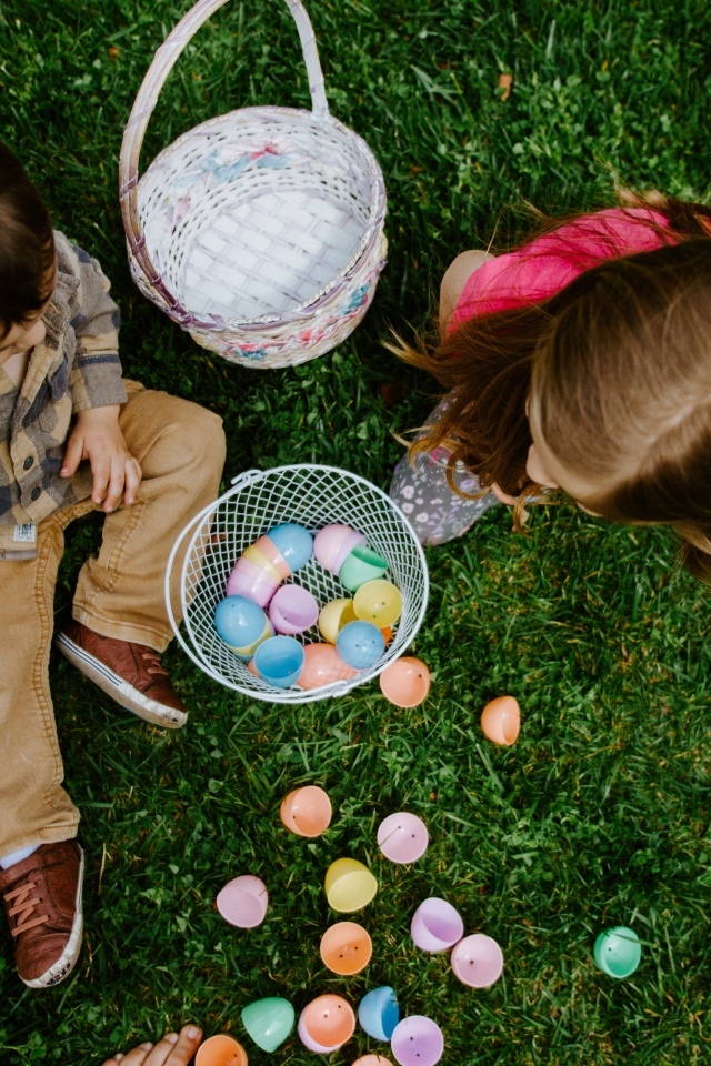 Дети играют на траве с пасхальными яйцами
