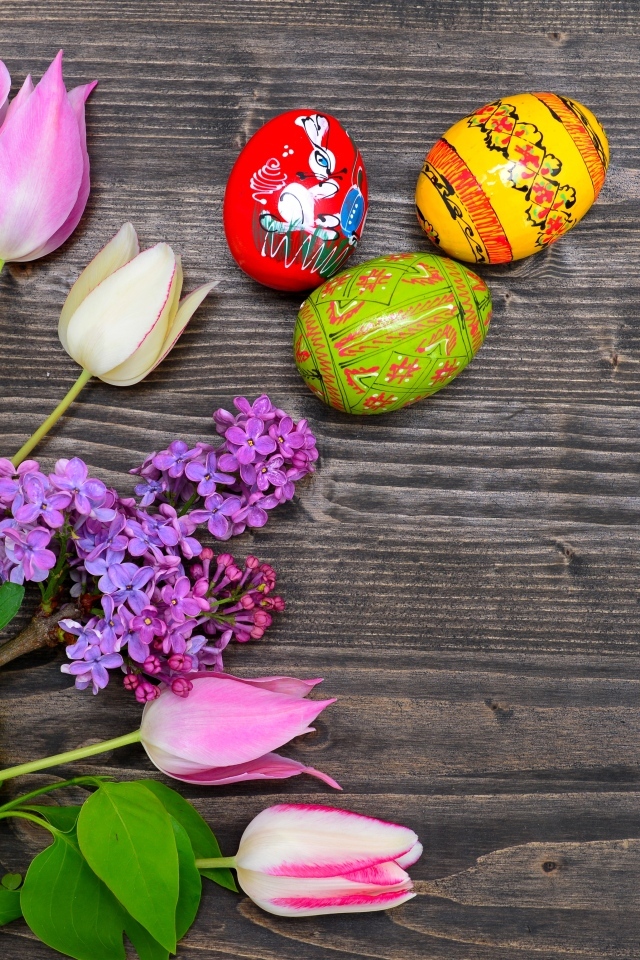 Пасхальные яйца с живыми цветами на столе 