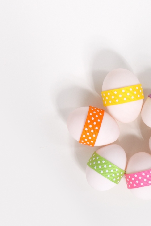 Белые яйца с ленточками на белом фоне