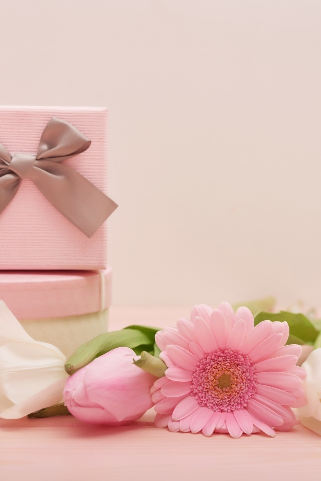 Bouquet and gifts on a pink background for International Women's Day