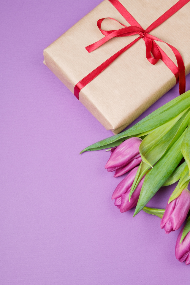 Подарок и букет красивых тюльпанов на сиреневом фоне