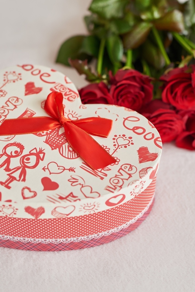 A heart-shaped box and a bouquet of roses for a girl on February 14