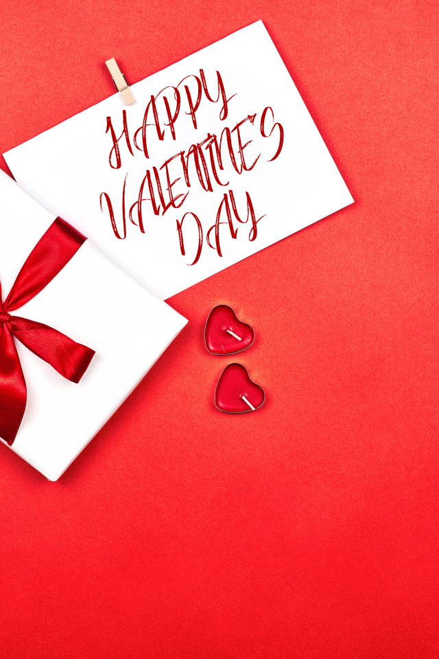 Открытка и подарок на красном фоне на День Святого Валентина