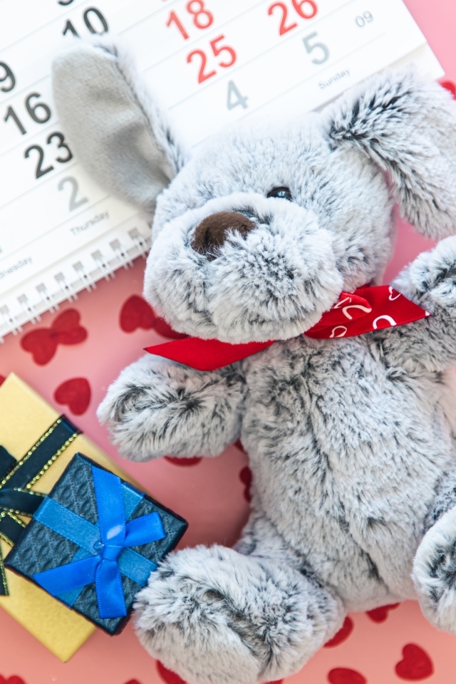 Игрушка и календарь на розовом фоне