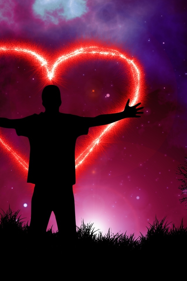 Мужчина рисует красное сердце в ночном небе