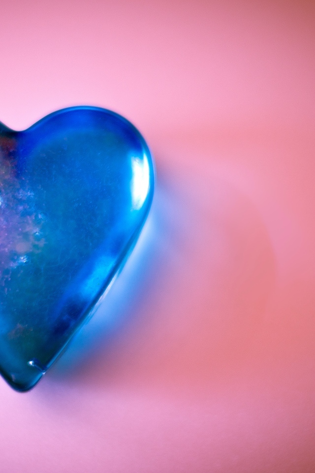 Синее стеклянное сердце на розовом столе