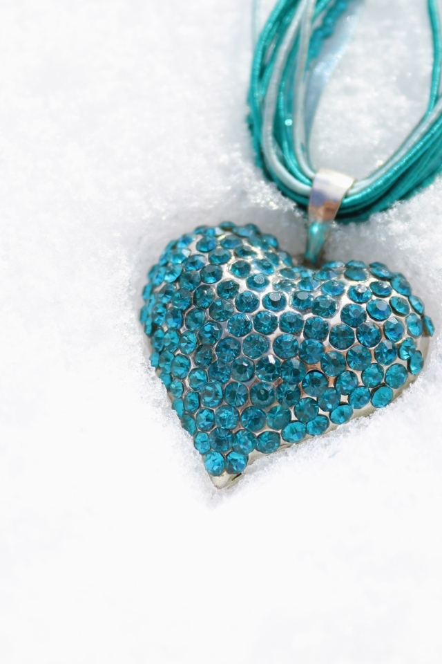 Голубой кулон в форме сердца на снегу
