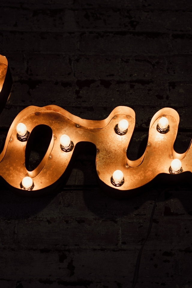 Светящаяся надпись любовь на черной стене