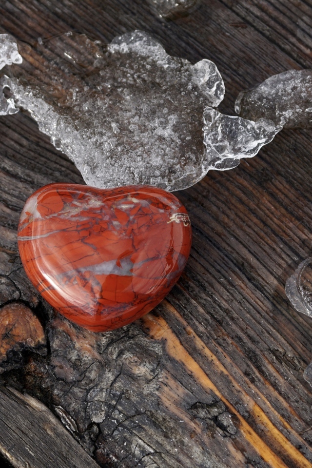 Сердце из камня на деревянной лавке с тающим снегом