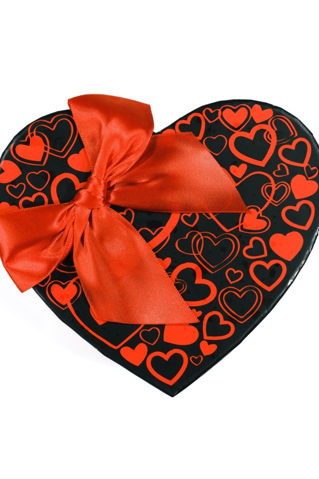 Большая коробка в форме сердца с красным бантом на белом фоне