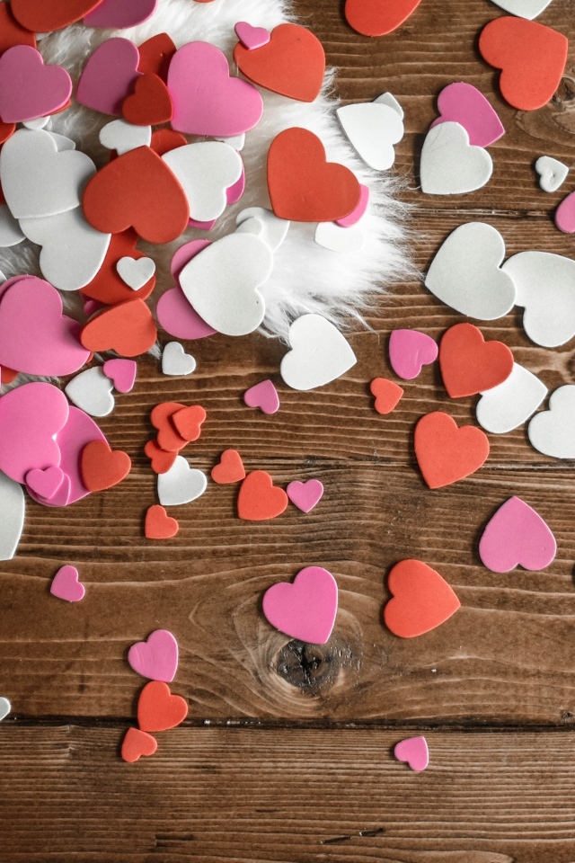 Много бумажных сердечек на деревянном полу