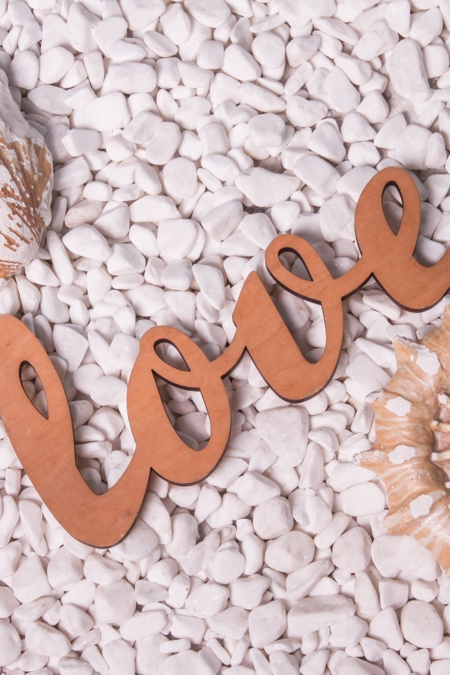 Ракушки и надпись любовь на белых камнях