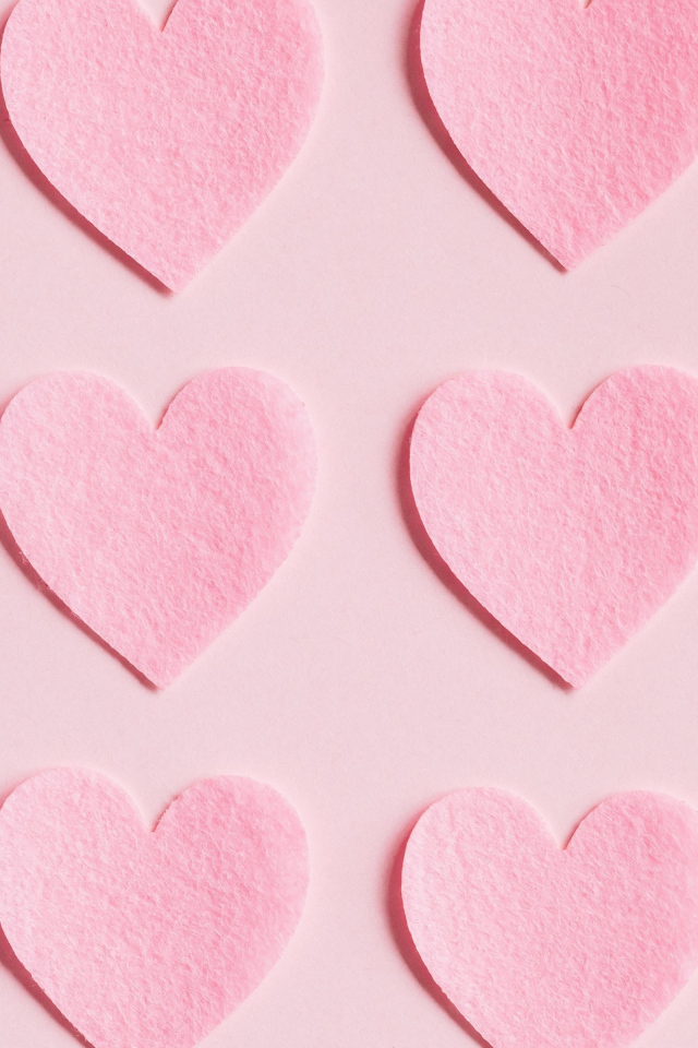 Маленькие бумажные сердечки на розовом фоне