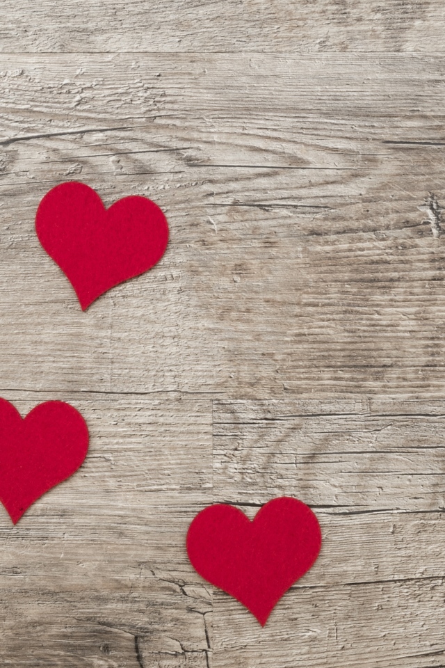 Маленькие красные сердечки на деревянном фоне