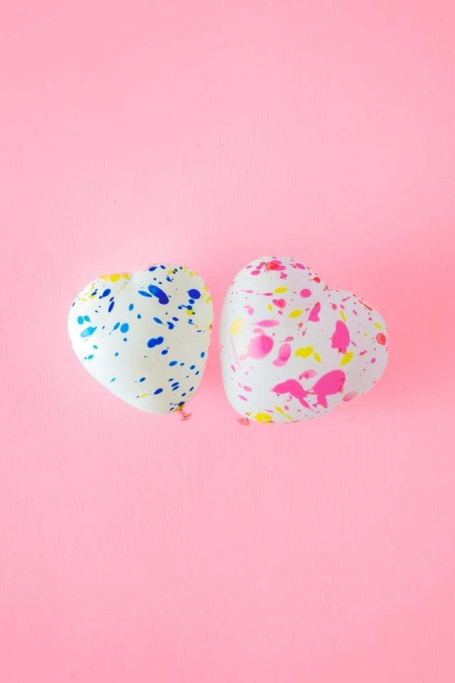 Два шарика в форме сердца на розовом фоне