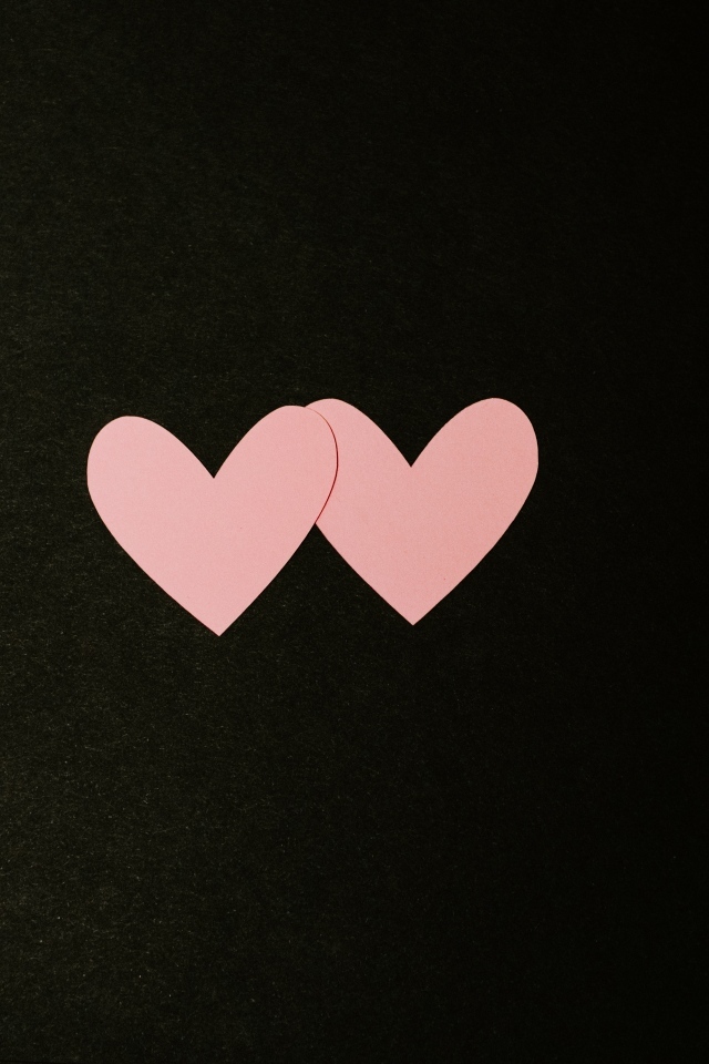 Два маленьких розовых сердца на черном фоне