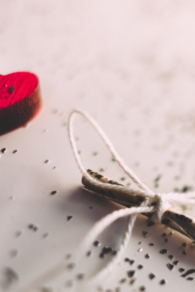 Два деревянных сердечка с запиской на столе