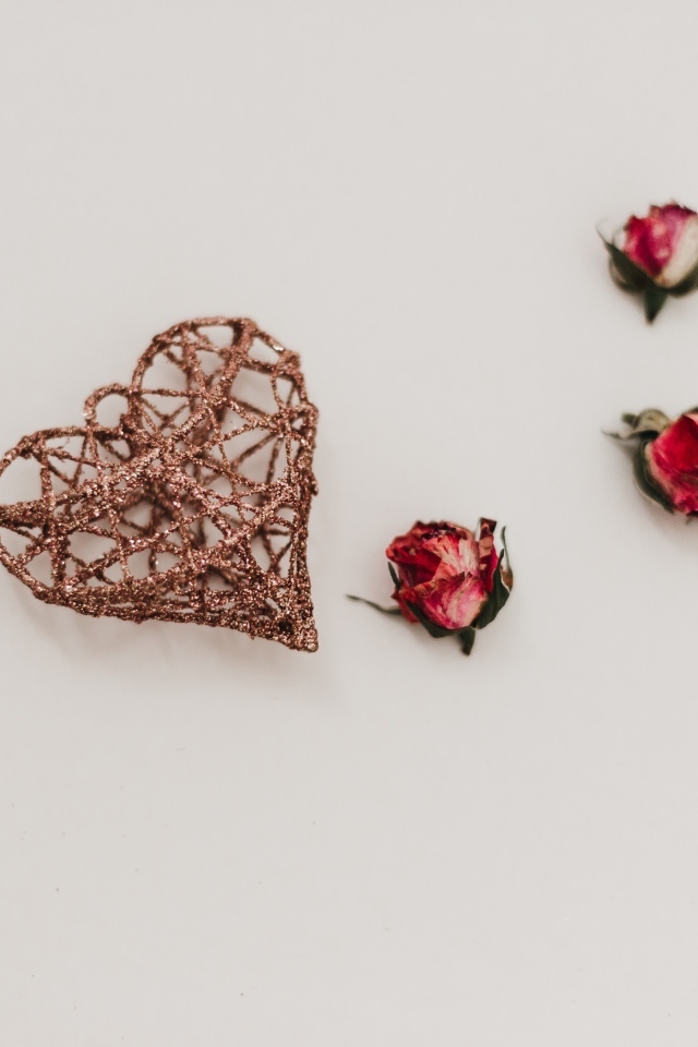 Плетеное сердце с сухими розами на сером фоне