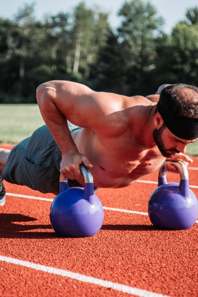 Мужчина спортсмен занимается с гирями