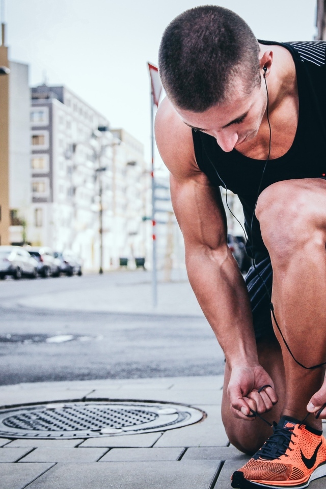 Мужчина спортсмен завязывает шнурки