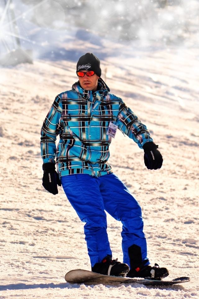 Мужчина сноубордист спускается по склону