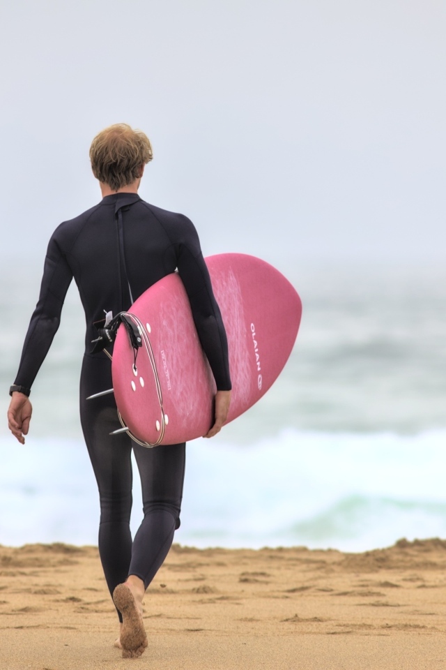 Мужчина серфингист идет к морю