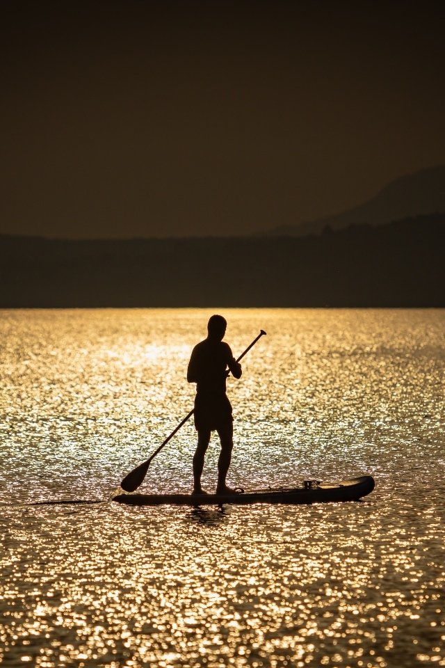 Мужчина серфингист в море на закате