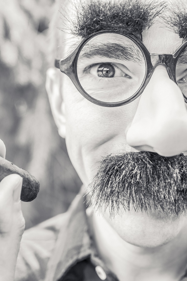 Мужчина в очках с сигарой в руке