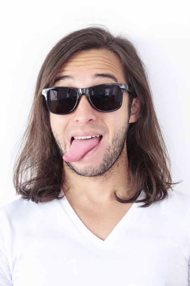 Мужчина в очках с высунутым языком