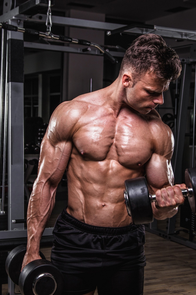 Сильный мужчина качает мускулы 