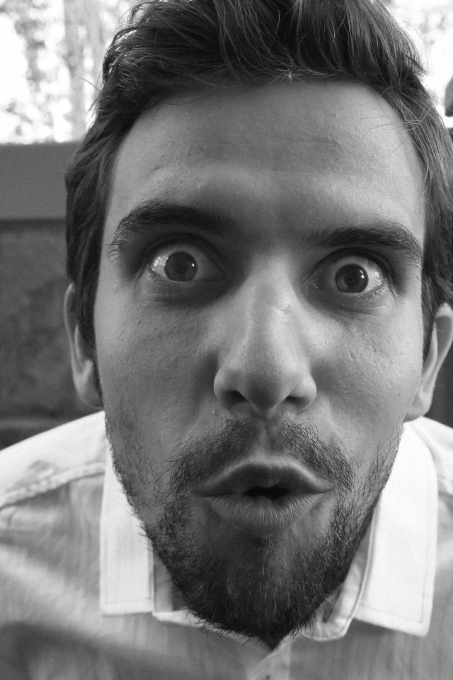 Удивленный взгляд мужчины в белой рубашке