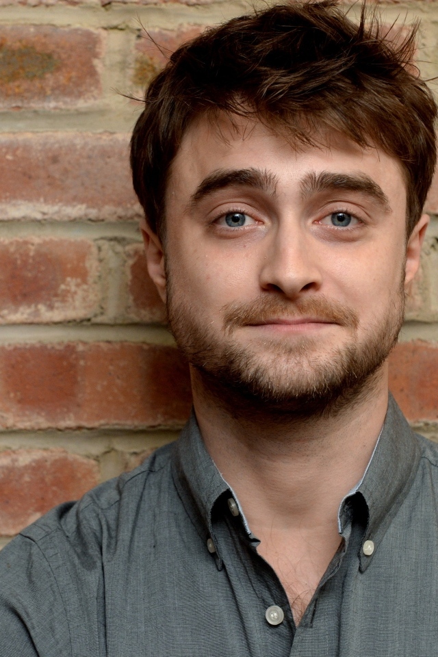 Актер Дэниел Рэдклифф стоит у стены