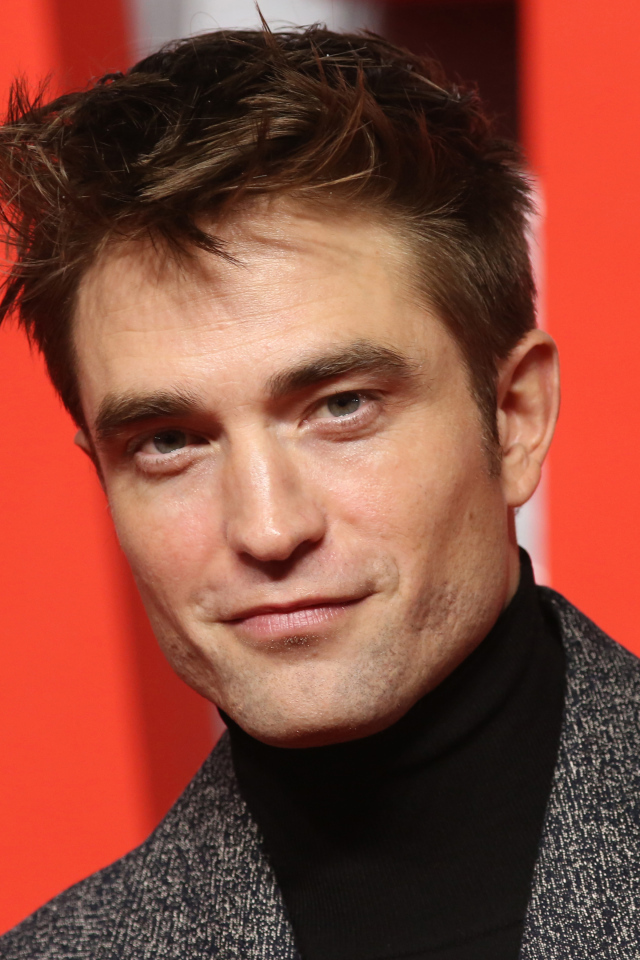 Актер Роберт Паттинсон на красном фоне