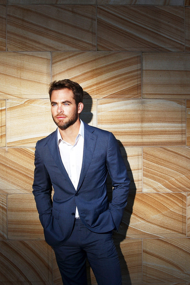 Американский актер Крис Пайн в костюме у стены