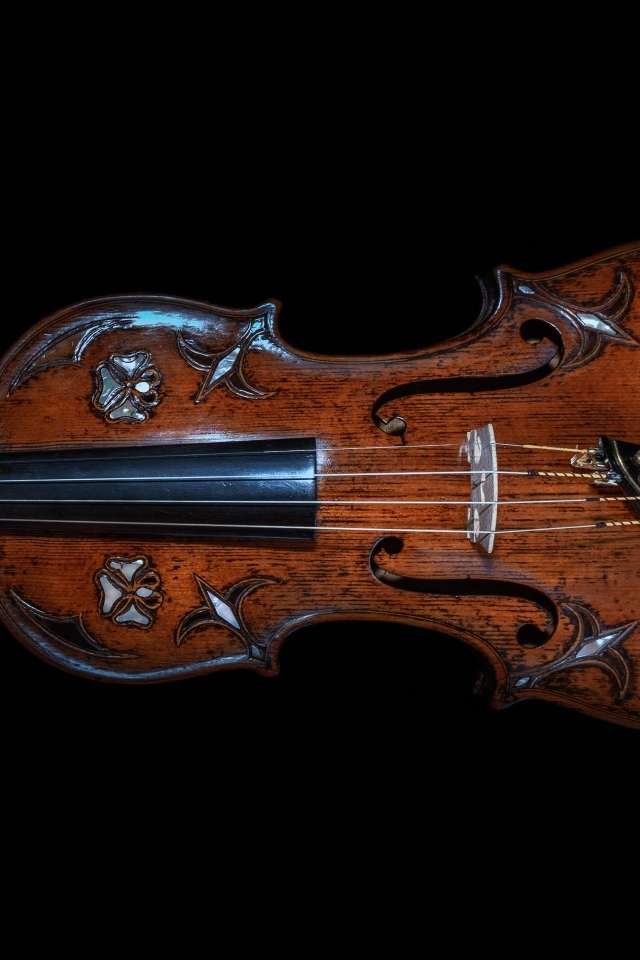 Большая деревянная скрипка на черном фоне