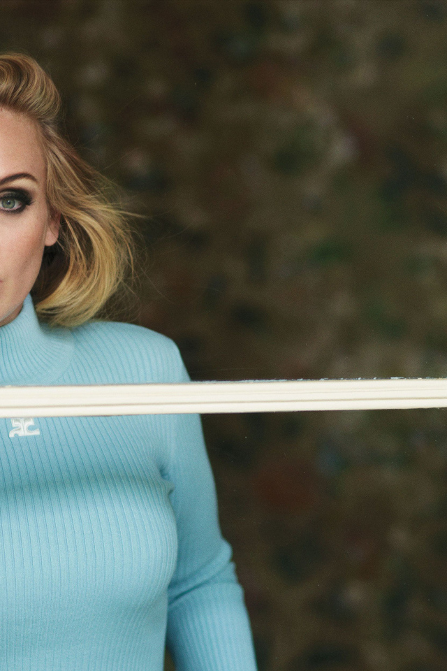 Певица Адель стоит у окна