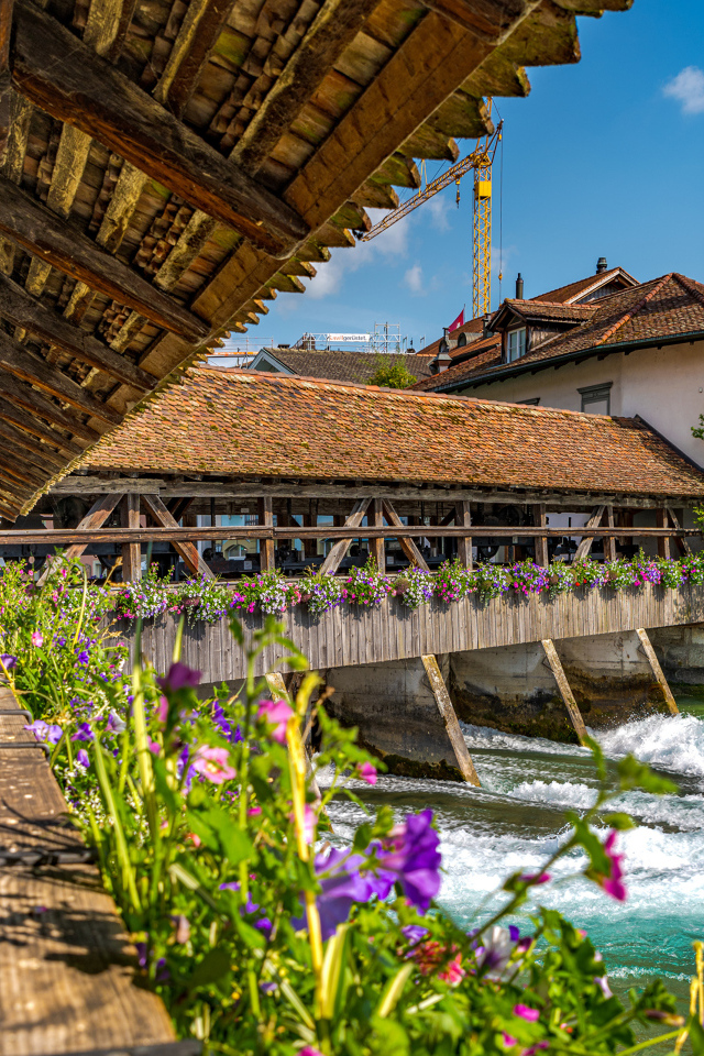 Красивый деревянный мост с цветами через реку