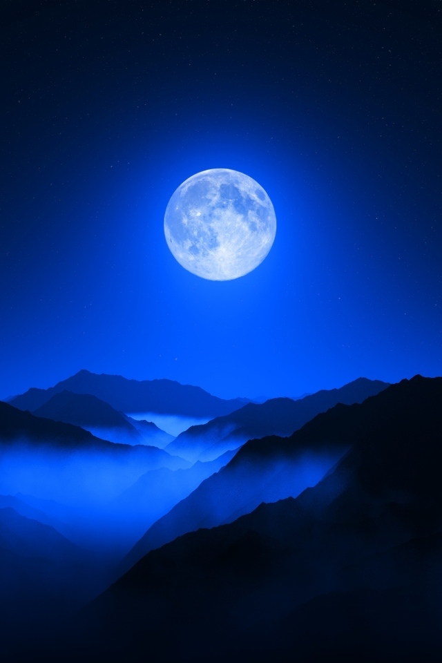 Большая луна в ночном небе над горами