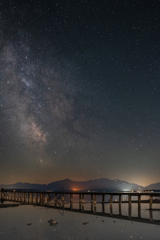 Млечный путь в небе над ночным фьордом